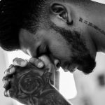 man tattooed praying